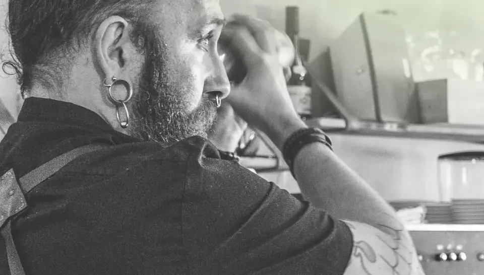 Retrato en blanco y negro de un miembro del equipo de Raizes en la barra