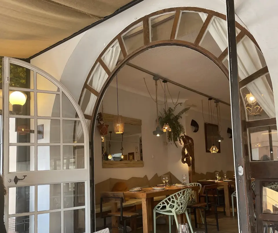 Arcos de madera y lámparas colgantes en el interior de Raizes
